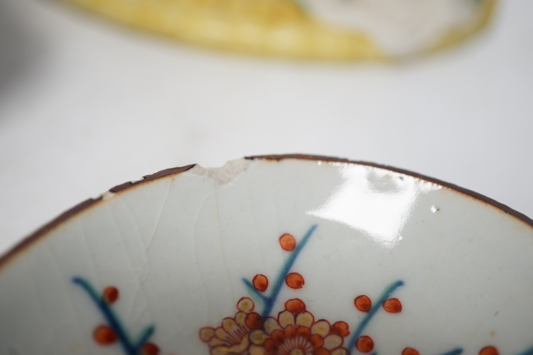 A Japanese seated porcelain figure of Kwannon, an Imari dish and a kakiemon style dish, largest 35cm diameter (3). Condition - blue dish good, others poor to fair